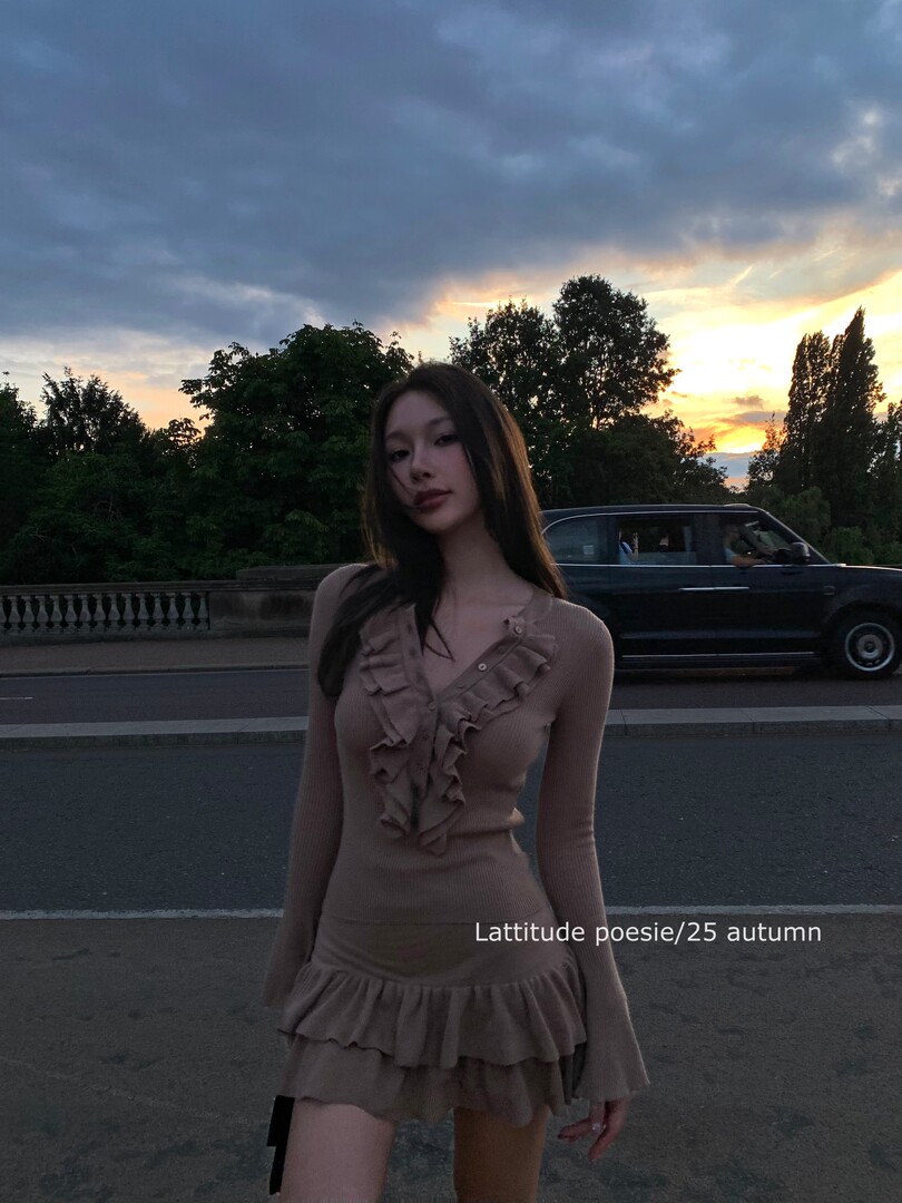 Woman wearing a taupe ruffled long-sleeve mini dress outdoors at sunset