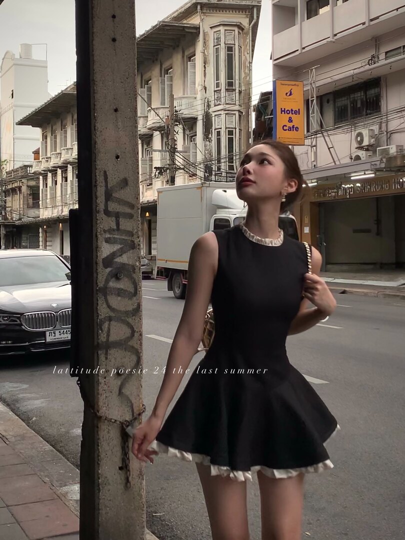 Black sleeveless flared dress worn by a woman on a city street