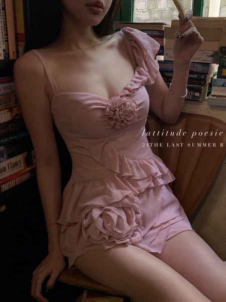 Pink ruffled mini dress worn by a model with floral accents