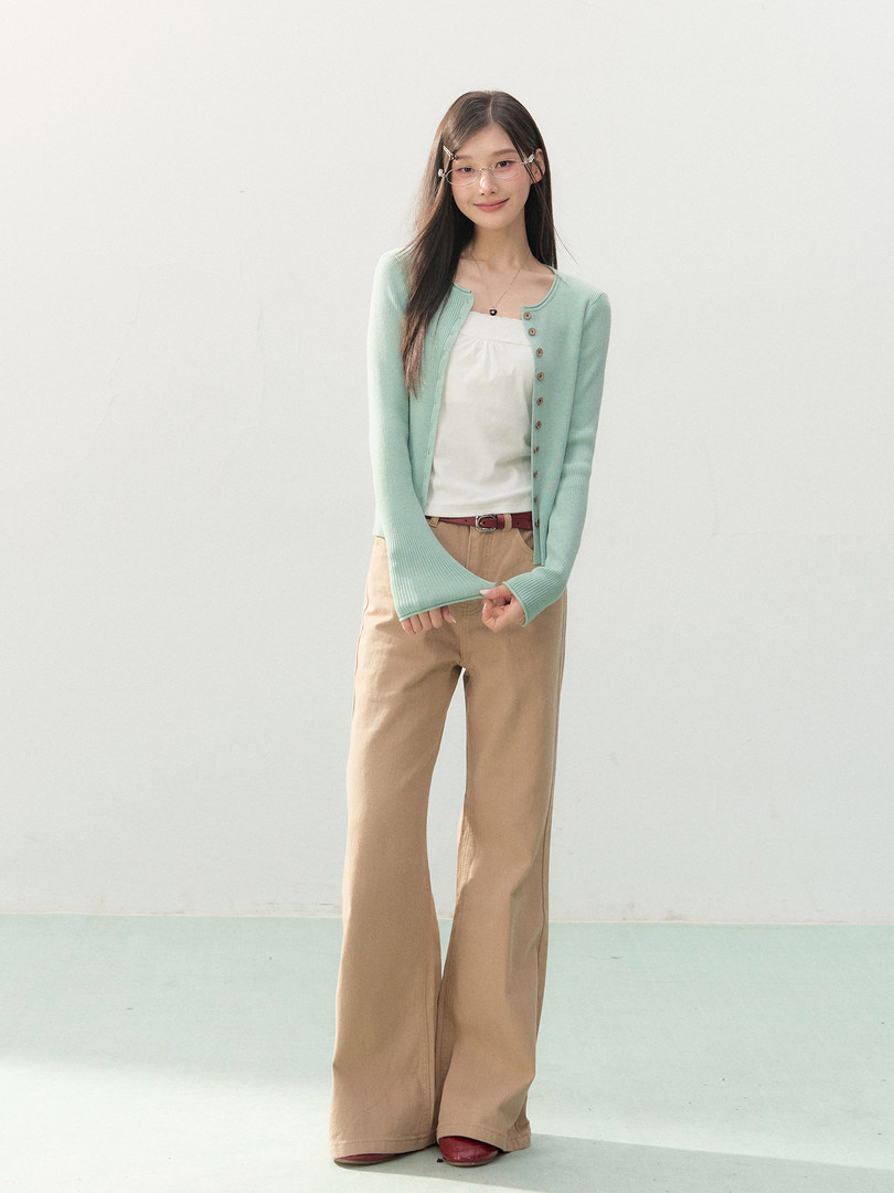 Model wearing a mint cardigan, white top, and beige wide-leg pants