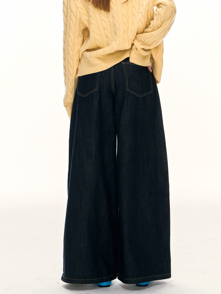 Model wearing dark wide-leg jeans with a cream cable-knit sweater