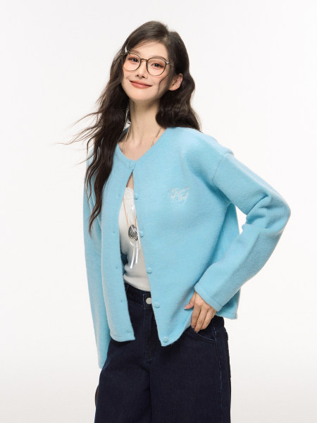 Model wearing a light blue cardigan over a top with dark jeans