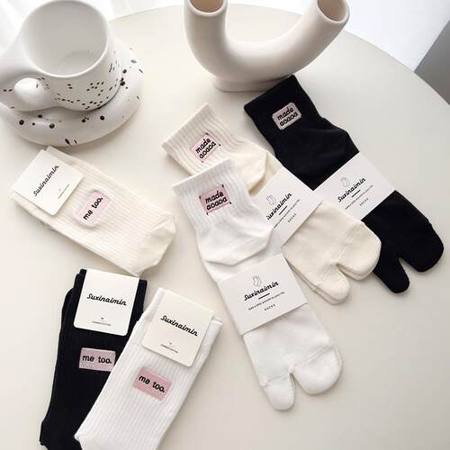 Suxinaimin, black and white, socked toes against the tampons
