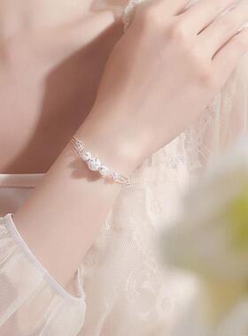 More than three layers of silver-plated bracelets, and a lit