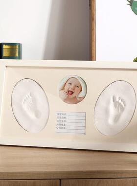 The babys handprints are covered with the babys footprints