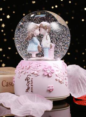 A romantic couple with a crystal ball box decorated a snowfl
