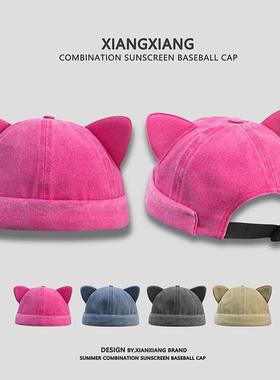 A cute cat with an earless head and a big summer cap with an