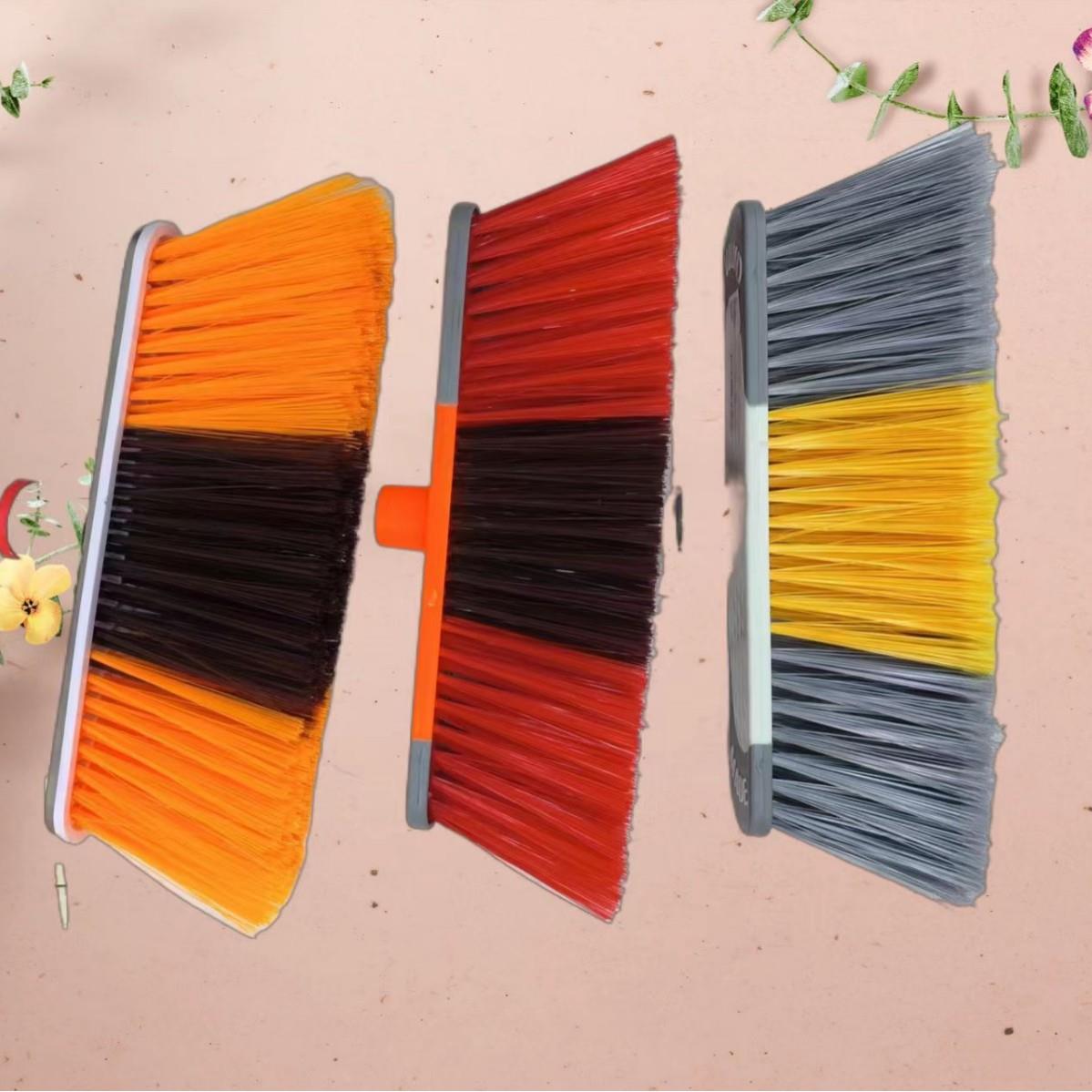 Various styles of plastic brooms, broom heads, and dual-colo