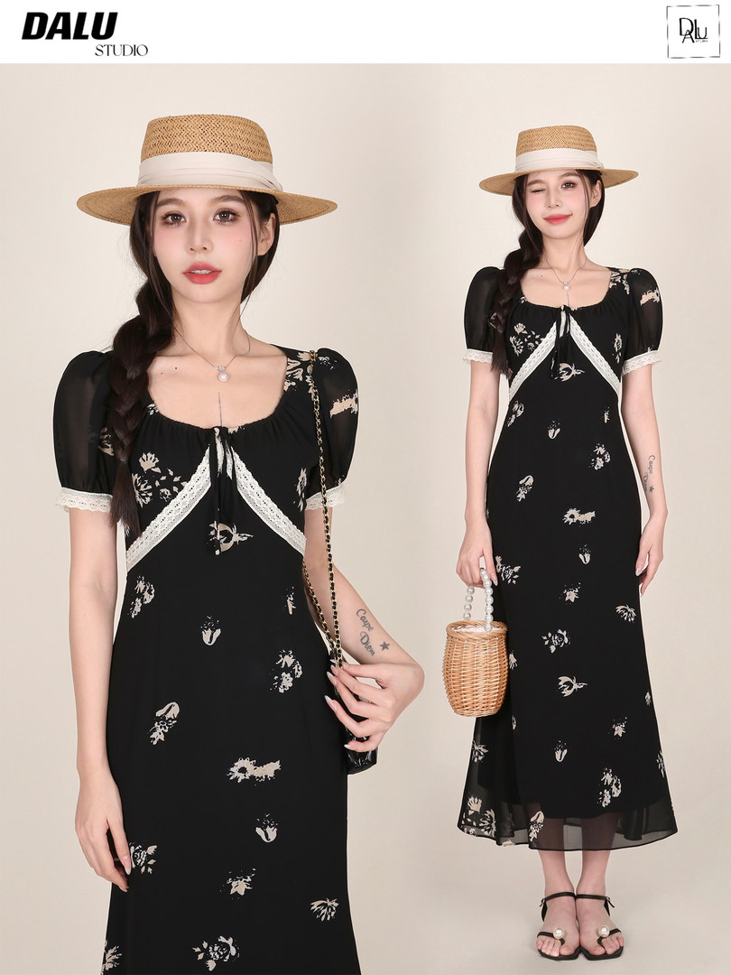 Black floral midi dress worn by a model with a straw hat and woven handbag
