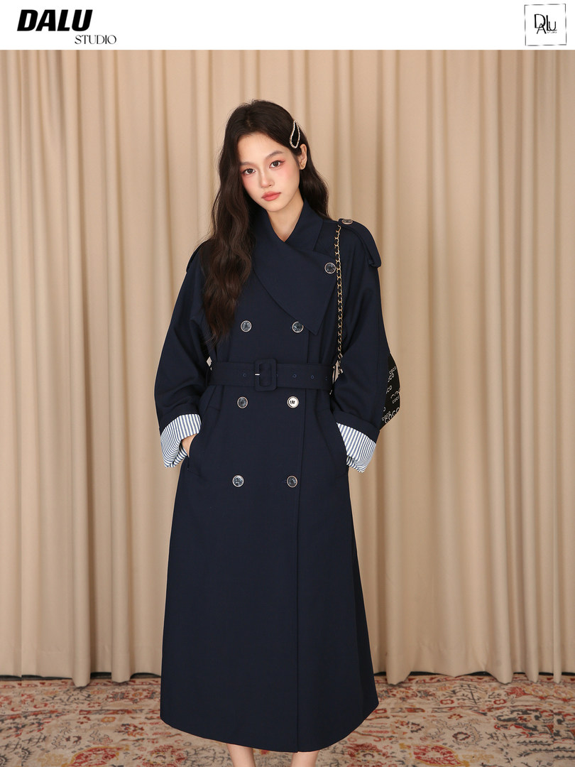 Model wearing a navy belted double-breasted coat