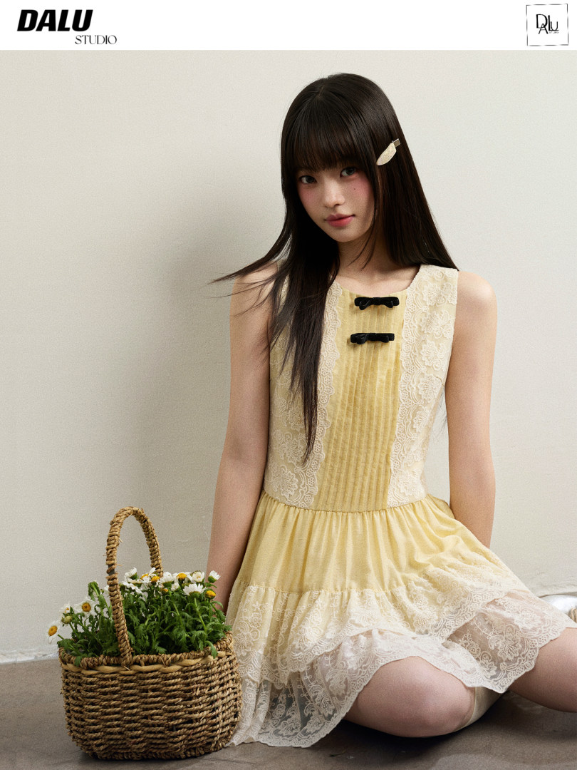Model wearing a yellow lace-trim sleeveless dress
