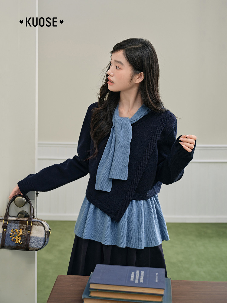 Model wearing a layered navy and light blue knit outfit with a matching scarf