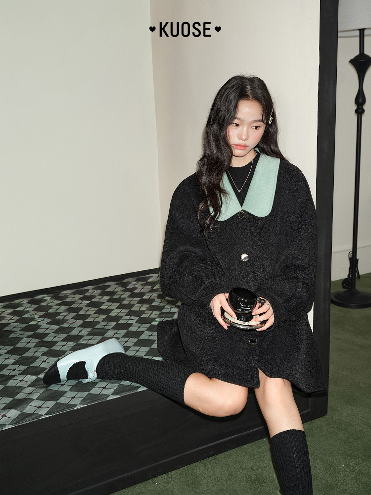 Model wearing a black coat dress with a mint green collar