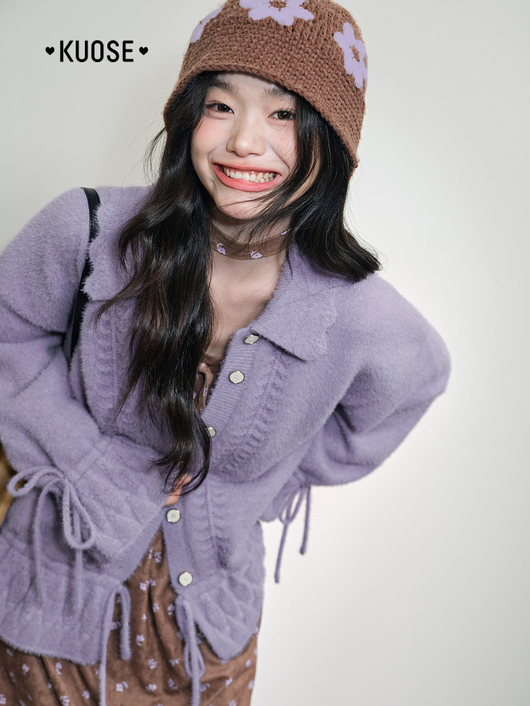 Model wearing a lavender fuzzy cardigan and brown knit hat