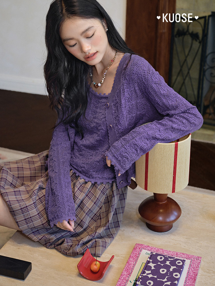 Model wearing a purple knit cardigan with a plaid skirt