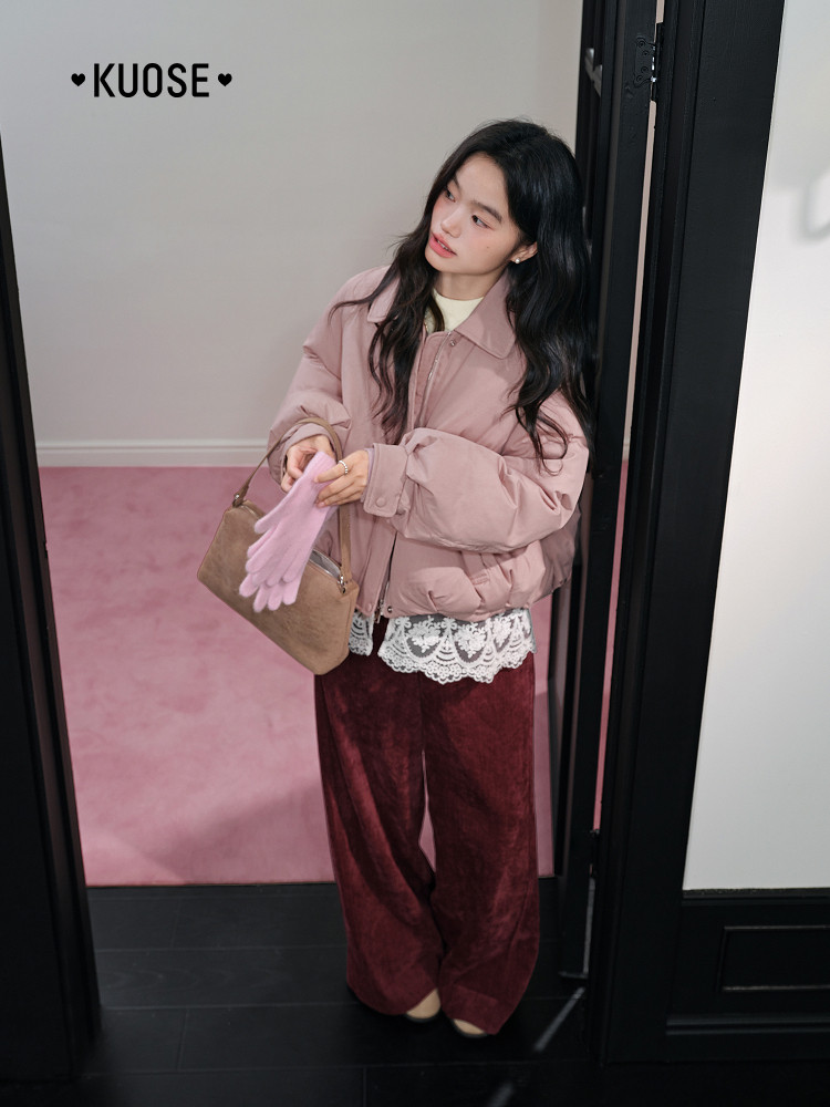 Model wearing a pink puffer jacket with burgundy wide-leg pants and a small handbag