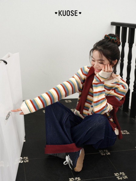 Model wearing a colorful striped sweater with wide-leg jeans