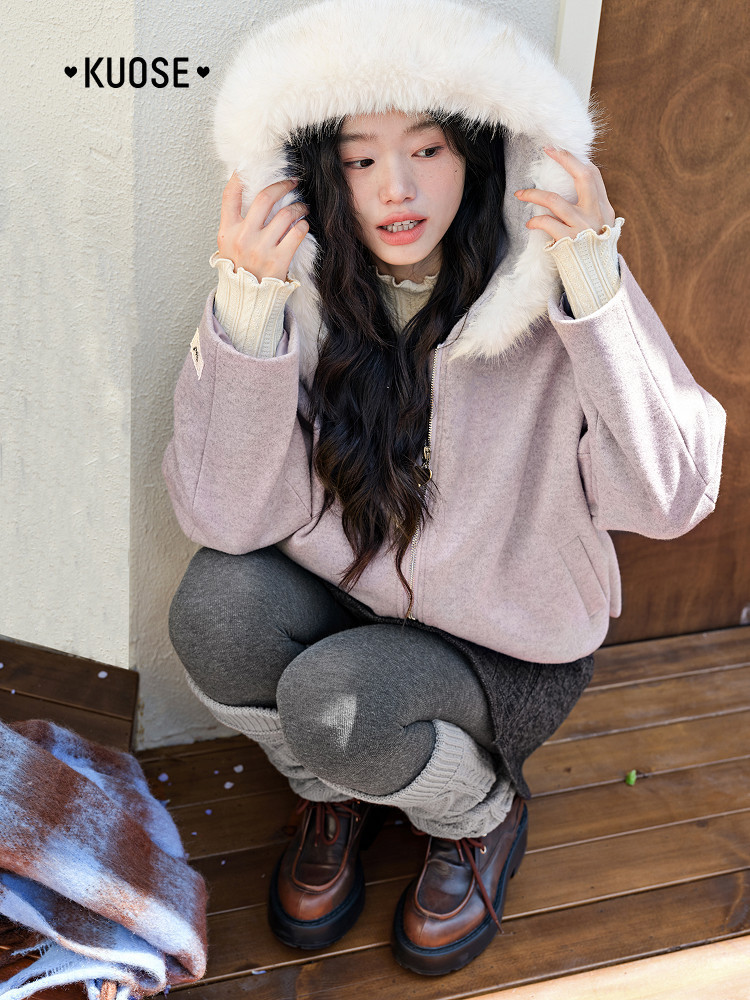 Woman wearing a light pink winter coat with a white fur hood