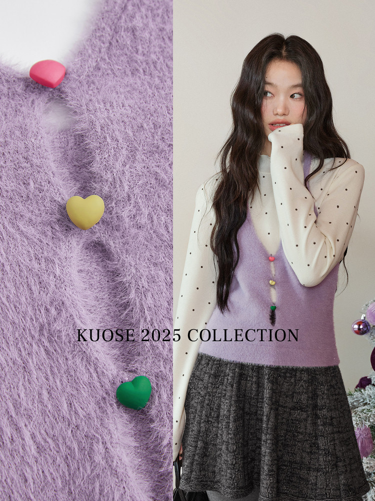 Model wearing a lilac fuzzy knit vest over a polka-dot blouse and dark skirt