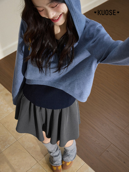 Woman wearing a blue hooded knit sweater with a layered skirt outfit