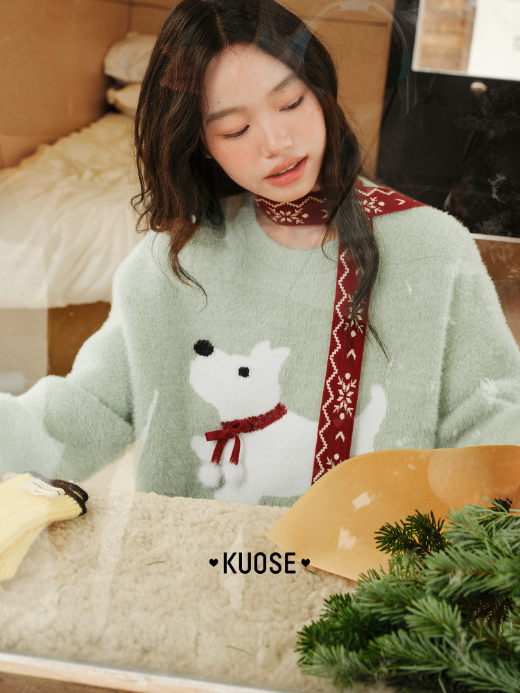 Model wearing a mint green fuzzy sweater with a dog graphic and red patterned scarf