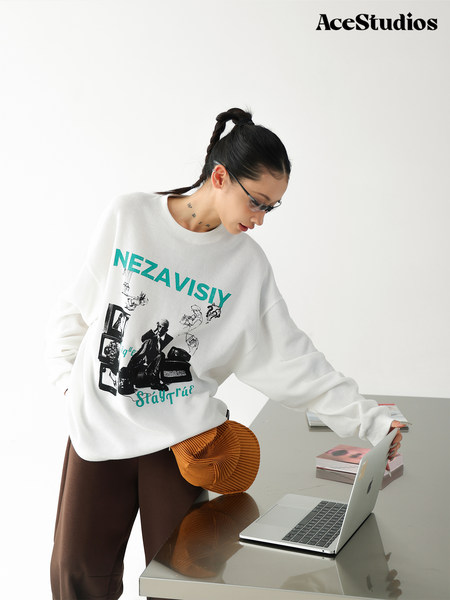 Model wearing a white graphic oversized sweatshirt with brown pants