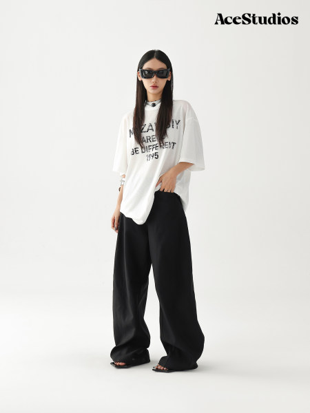Model wearing an oversized white graphic T-shirt and wide black pants