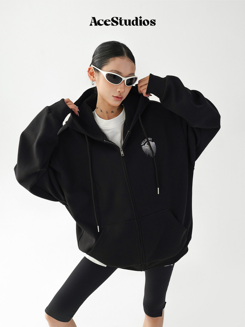 Model wearing a black oversized zip-up hoodie with white sunglasses