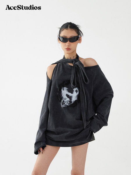 Black oversized off-shoulder graphic top worn by a model