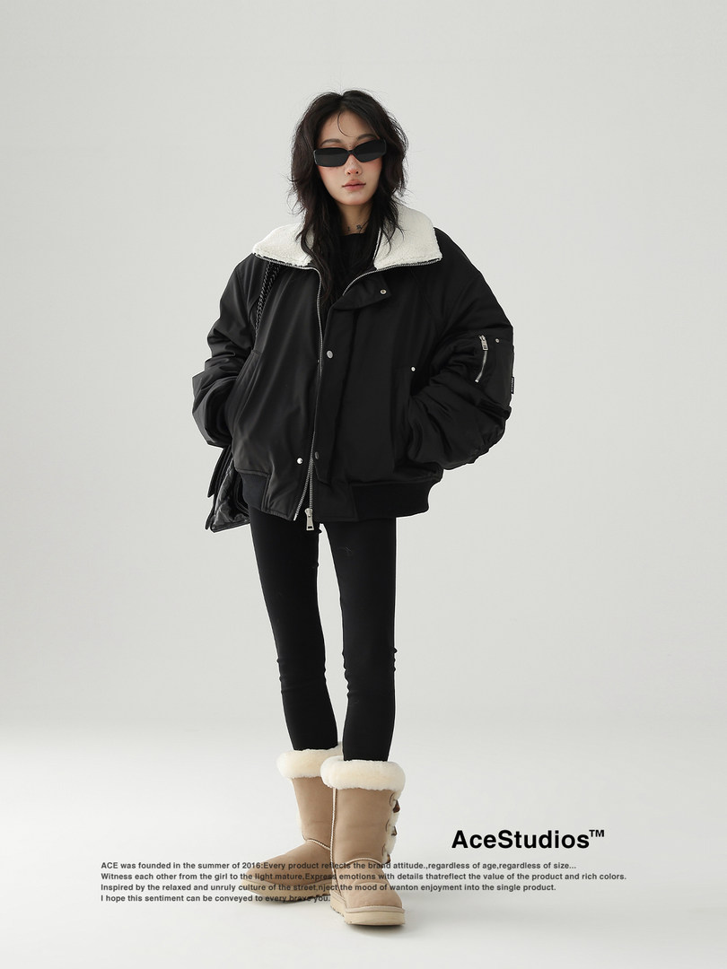 Model wearing a black oversized winter jacket with shearling collar and tan fur-lined boots