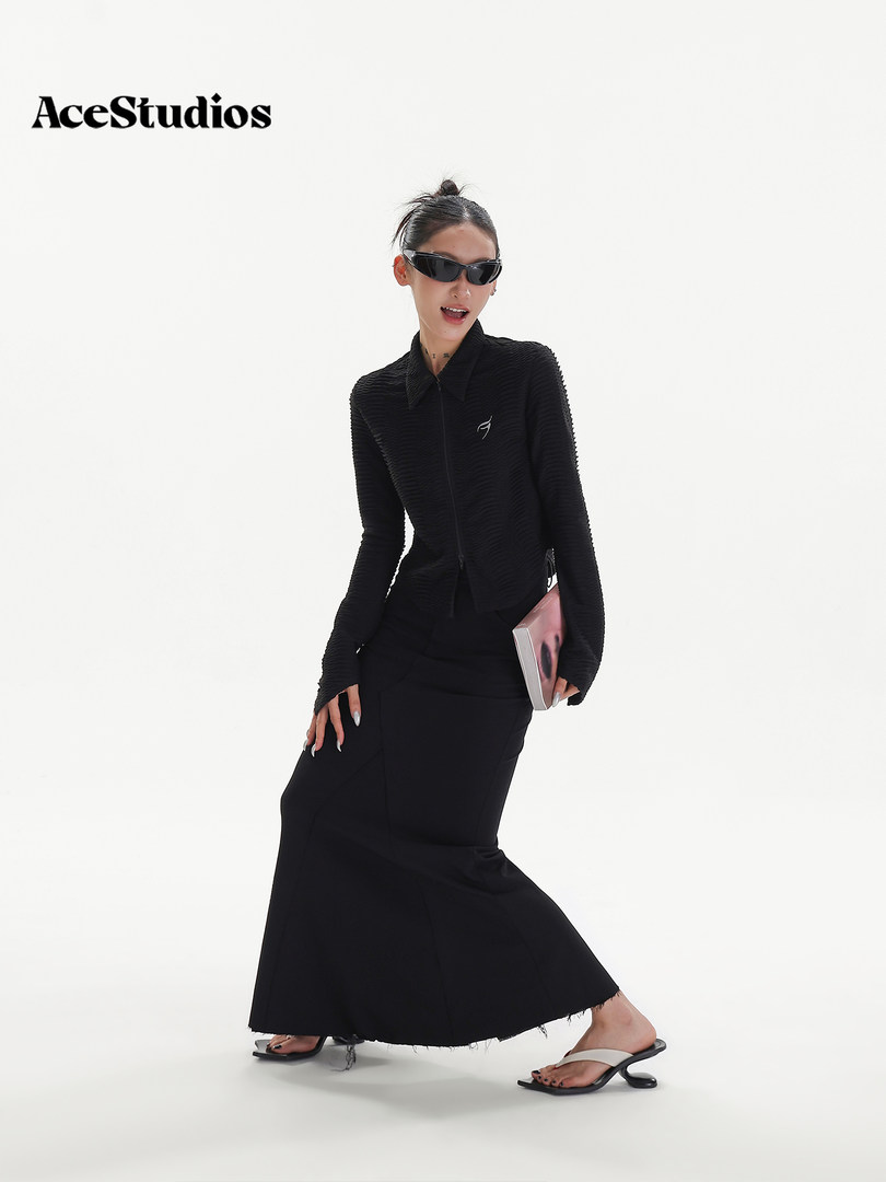 Black fashion outfit on model with zip-up jacket and long skirt