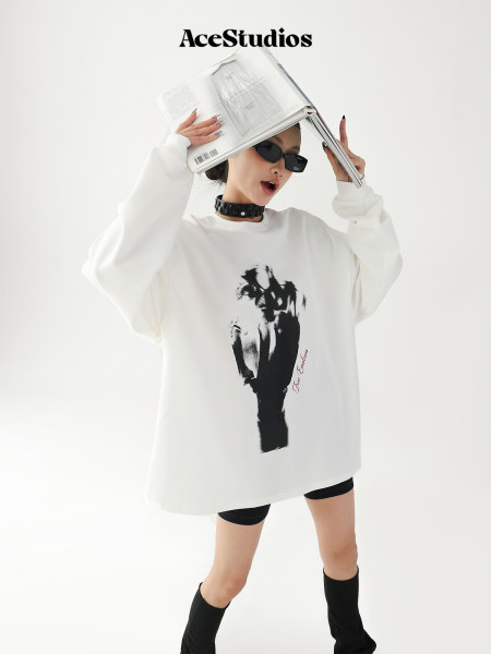 Model wearing an oversized white graphic sweatshirt with black print