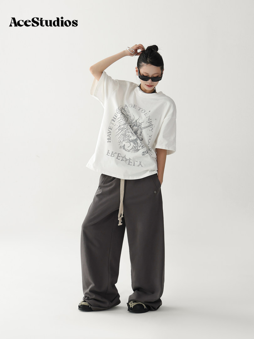 Model wearing an oversized graphic T-shirt with wide-leg dark pants