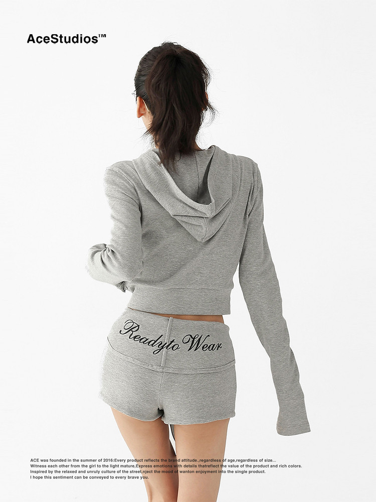 Model wearing a gray cropped hoodie and matching shorts set