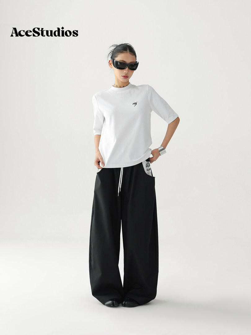 Model wearing a white short-sleeve top with black wide-leg pants
