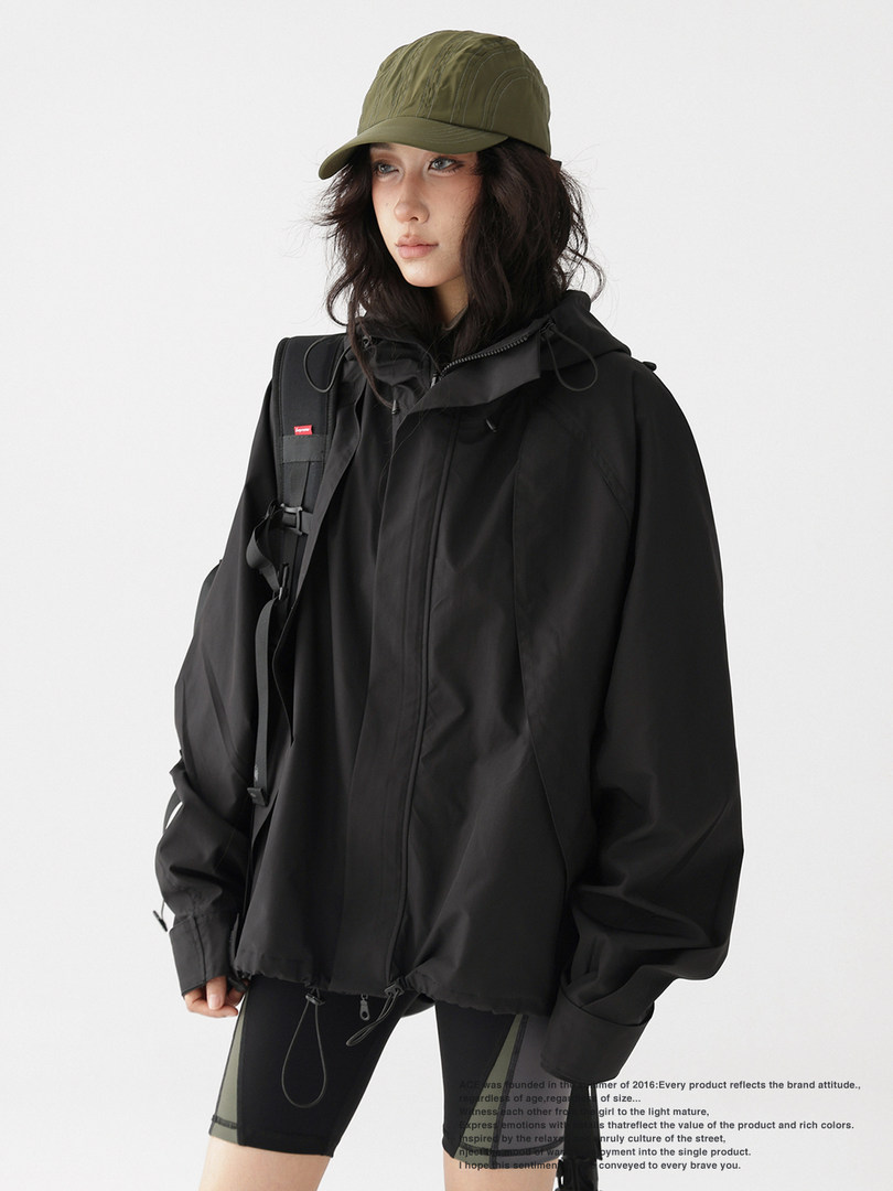 Model wearing a black oversized hooded jacket and cap
