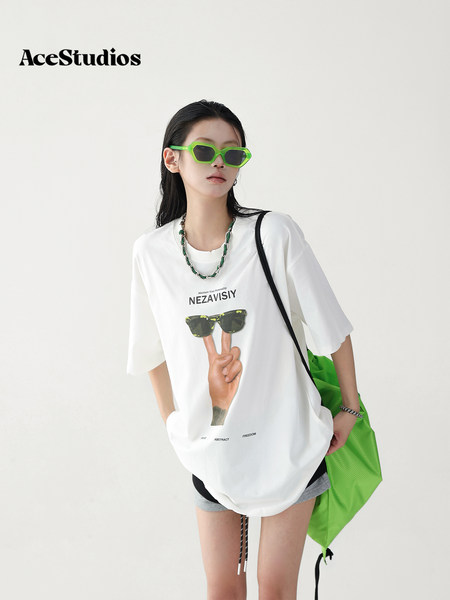 Model wearing an oversized white graphic T-shirt with neon green accessories