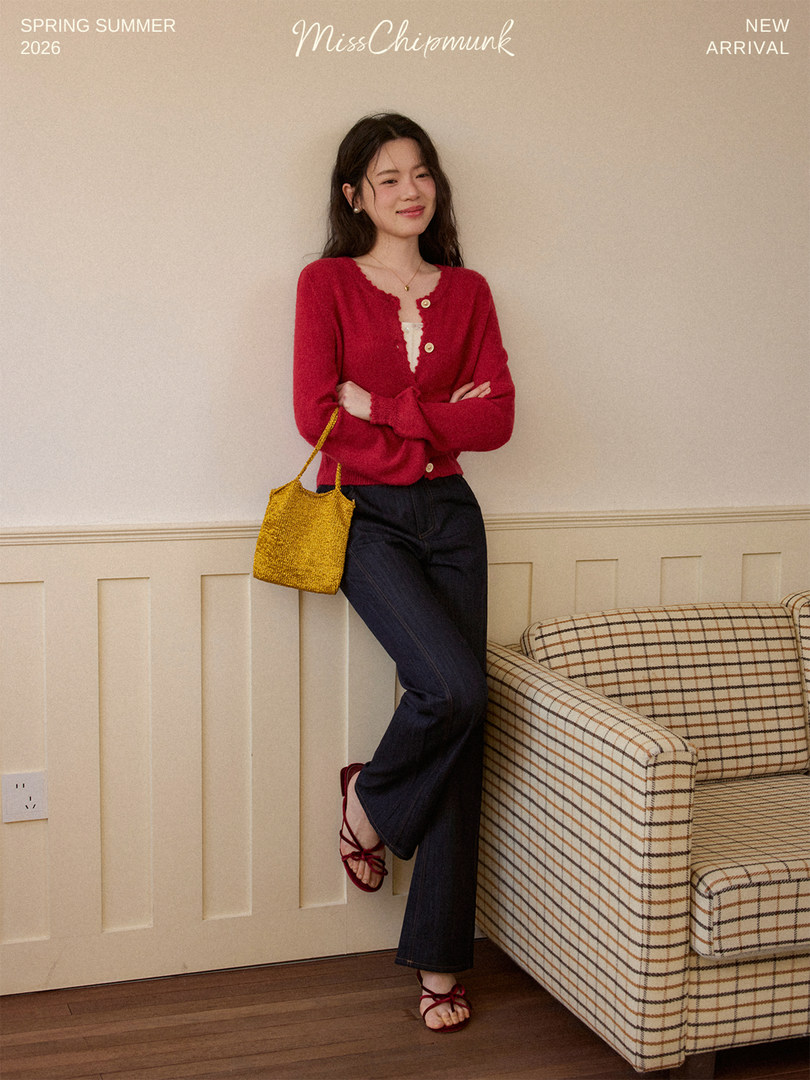 Woman wearing a red cardigan with dark jeans, red sandals, and a yellow handbag