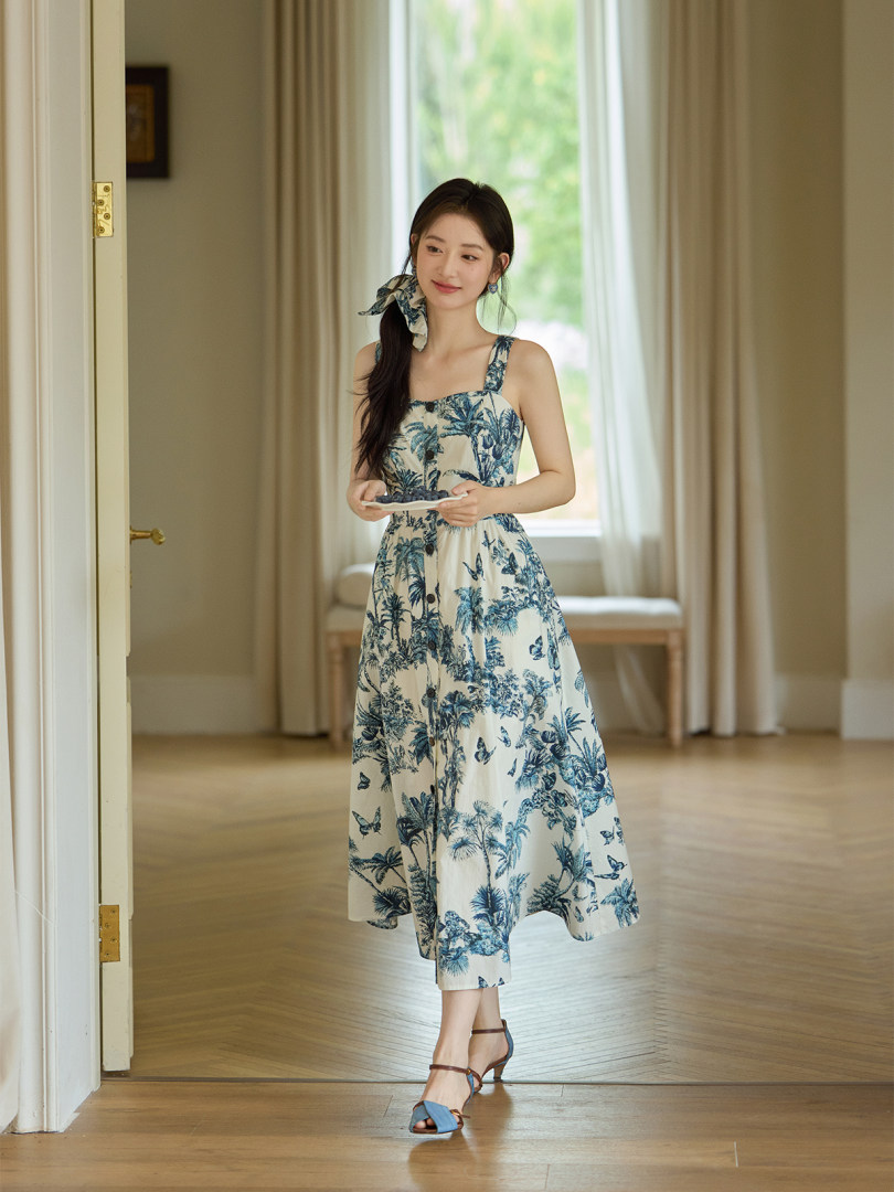 Woman wearing a blue and white tropical print midi dress