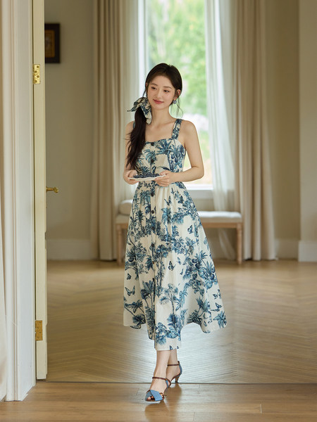Woman wearing a blue and white tropical print midi dress