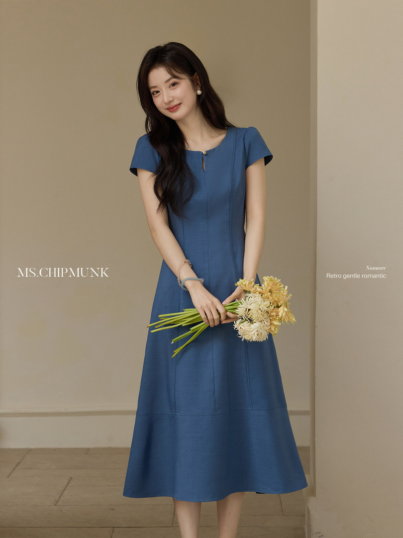 Woman wearing a blue midi dress holding flowers