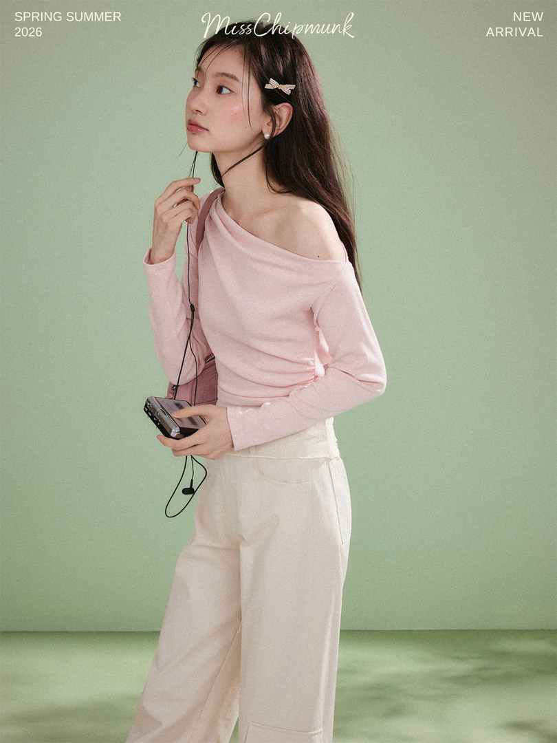 Model wearing a pink off-shoulder top with cream wide-leg pants