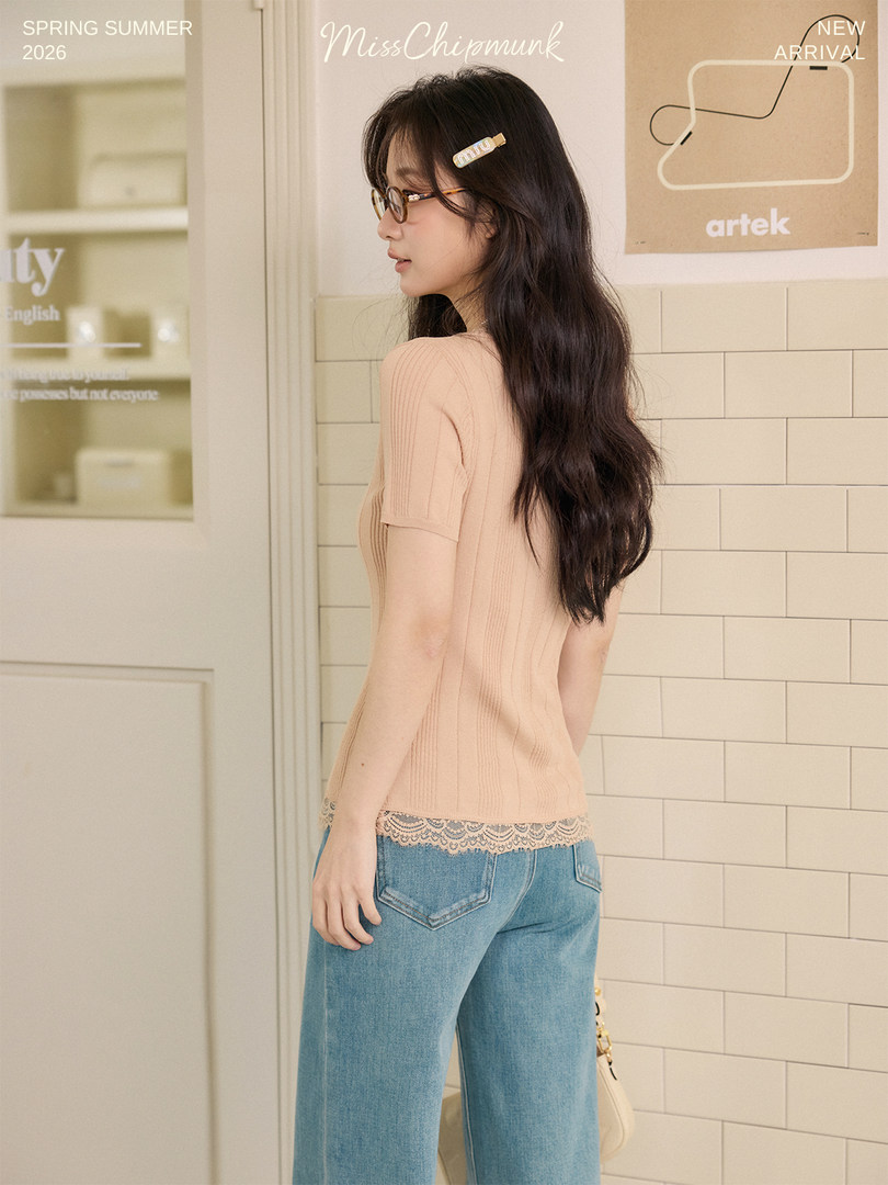 Model wearing a beige knit short-sleeve top with lace hem and jeans