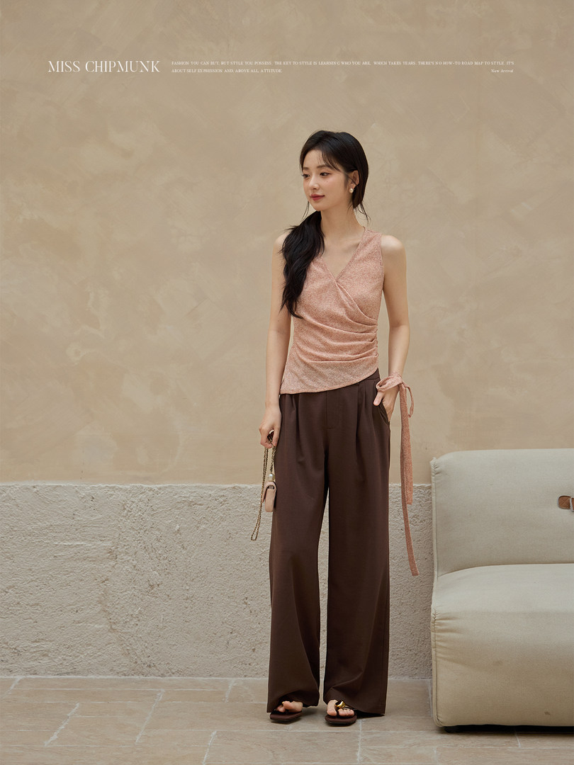 Model wearing a pink sleeveless wrap top with brown wide-leg pants