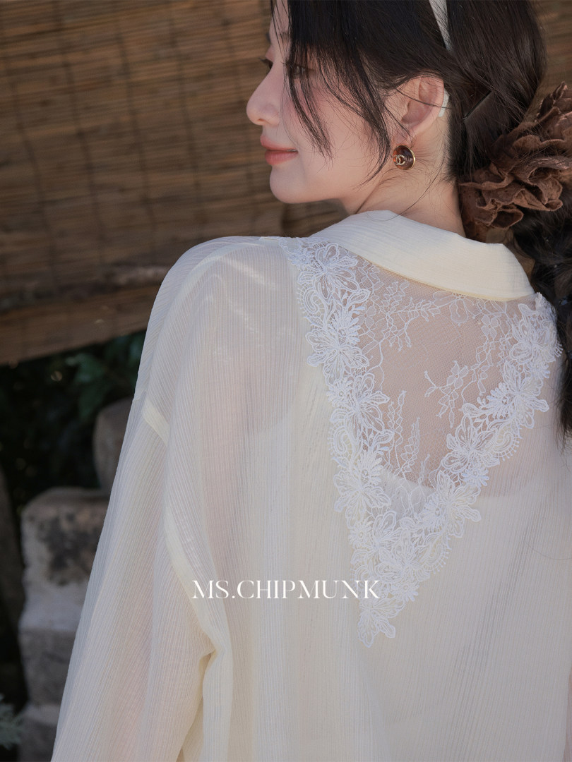 Woman wearing a sheer cream lace-back blouse on a model