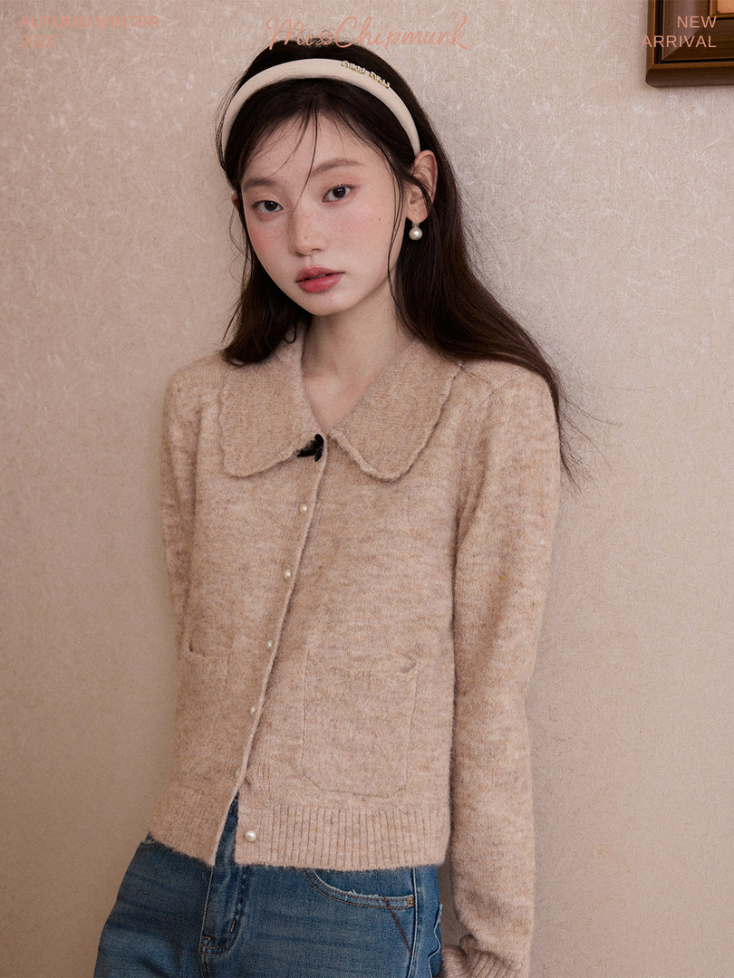 Woman wearing a beige fuzzy cardigan sweater with a Peter Pan collar
