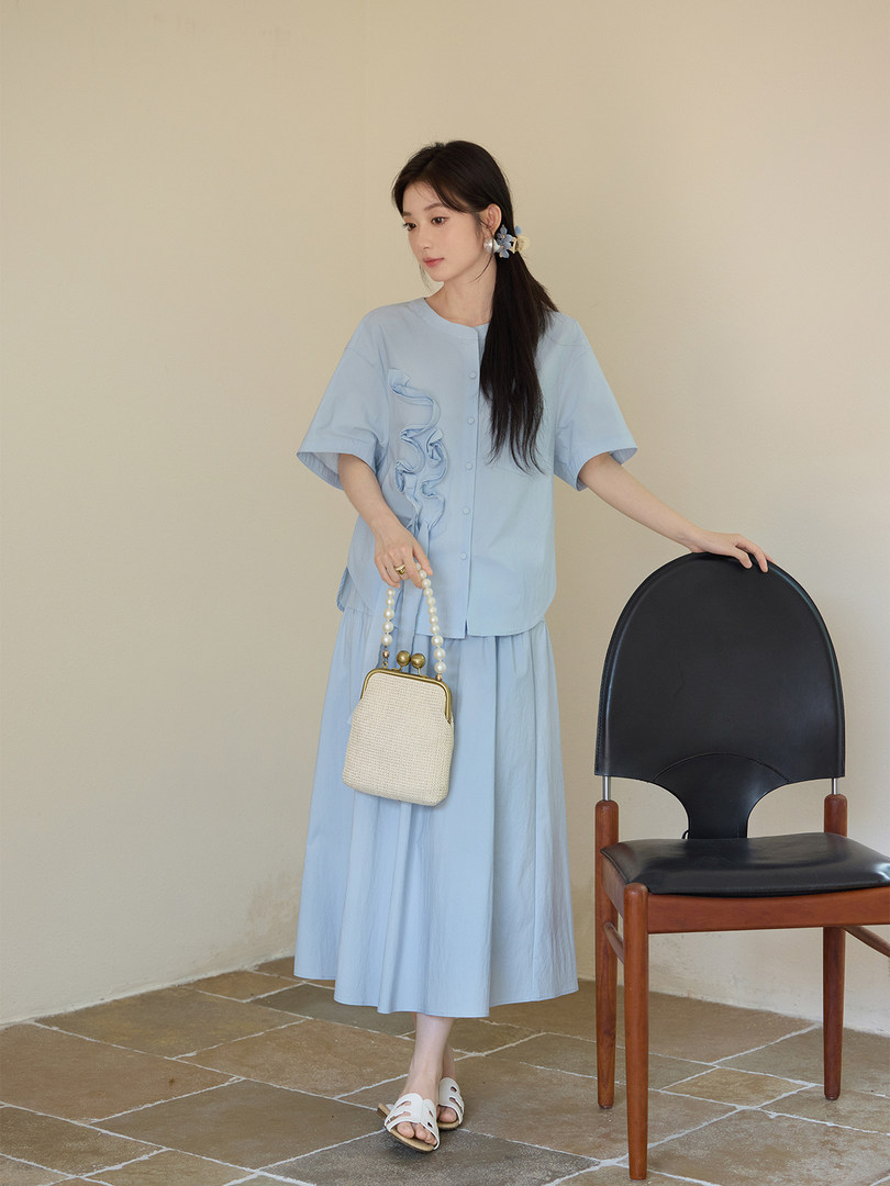 Light blue two-piece outfit worn by a model with a matching skirt and short-sleeve top