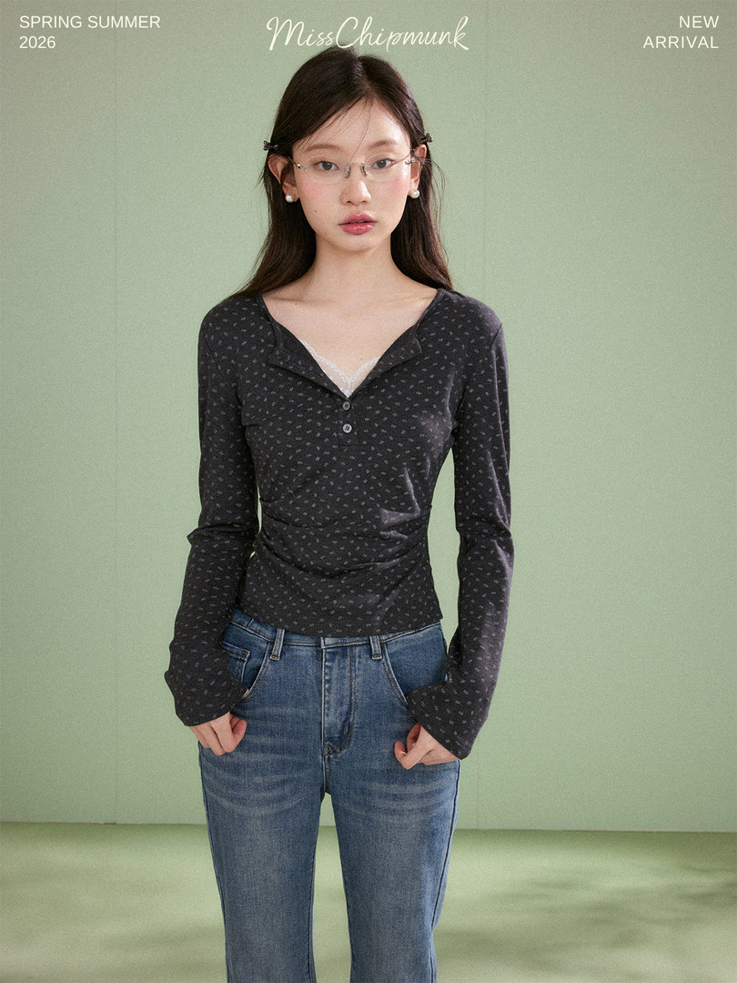Woman wearing a dark patterned long-sleeve top with jeans