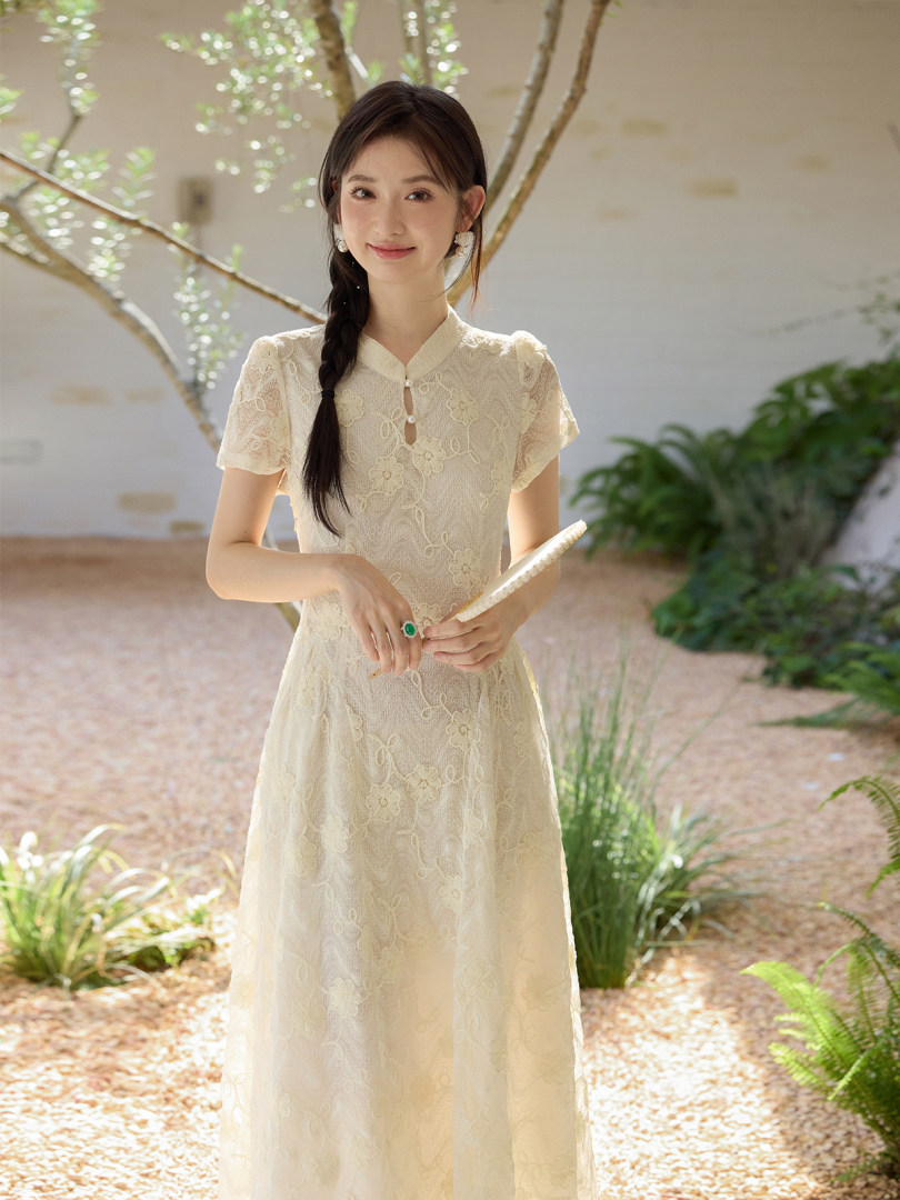 Woman wearing a cream lace short-sleeve dress outdoors