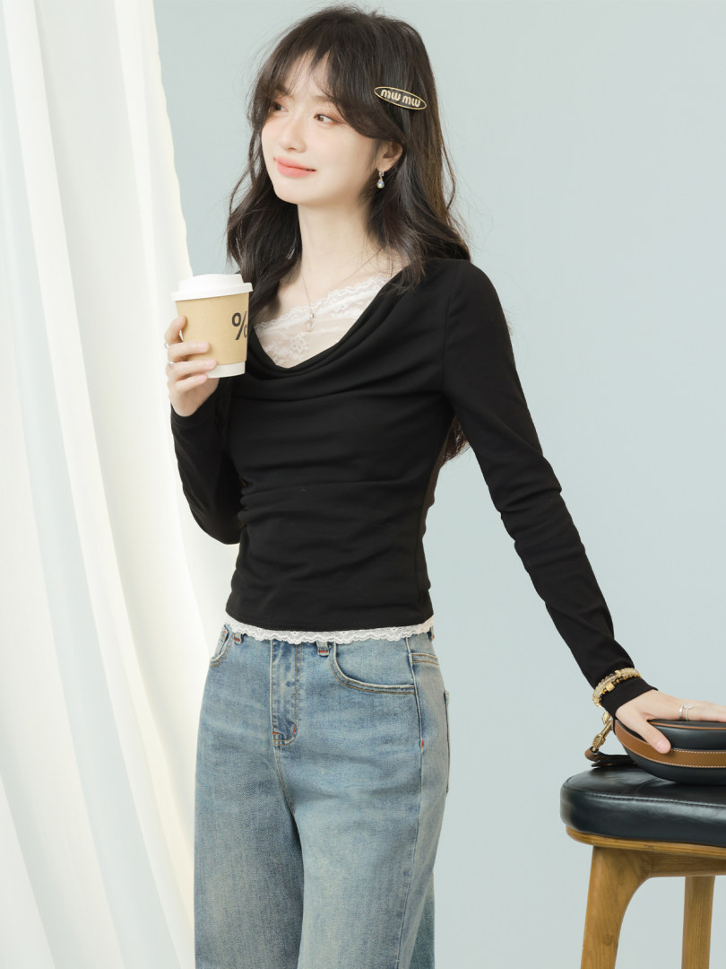 Woman wearing a black long-sleeve top with lace trim and light blue jeans